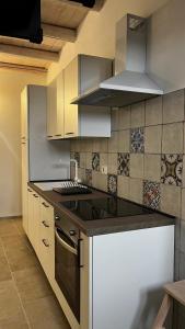 a kitchen with white cabinets and a stove top oven at Siculía in Noto +16 photos