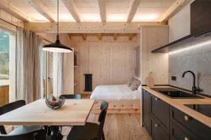a kitchen with a table and a bedroom with a bed at Agriturismo La Daga Nature Lodge in Auronzo di Cadore