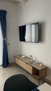 a living room with a table and a tv on the wall at Siculía in Noto