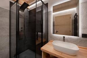a bathroom with a sink and a shower at Agriturismo La Daga Nature Lodge in Auronzo di Cadore