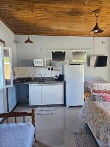 a kitchen with a white refrigerator in a room at Vila Sabará in Pinheiro