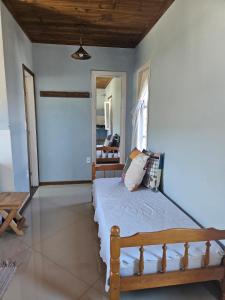 a bedroom with a wooden bed in a room at Vila Sabará in Pinheiro