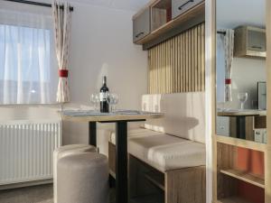 a dining room with a table and a bottle of wine at Guillemot in St Bees