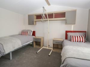 a bedroom with two beds and a lamp in it at Guillemot in St Bees