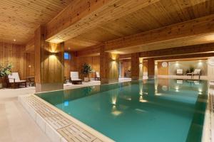 a swimming pool in a building with a wooden ceiling at Spåtind Fjellhotell in Nord Torpa