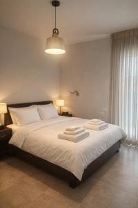 a bedroom with a bed with two towels on it at Alonas Apartments Beachfront Apartment in Haifa
