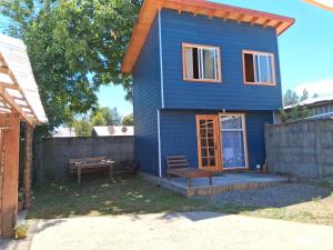 a blue house with a bench and a table at Mini departamento 3 in Coñaripe
