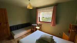 a small bedroom with a bed and a window at zielonapogoda in Lądek-Zdrój