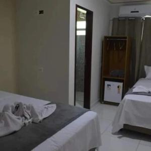 a bedroom with a bed and a dresser and a mirror at Flat Ubarana Maragogi-AL in Maragogi