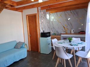 a living room with a table and chairs and a kitchen at Mini departamento 3 in Coñaripe