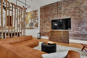 a living room with a couch and a brick wall at Luxe 220 Suite 3 in Wilmington