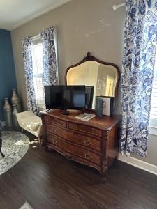 a room with a mirror and a dresser with a television on it at Barksdale House Inn in Charleston