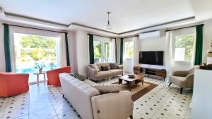 a living room with two couches and a tv at Dalyan Villa Amazon in Dalyan
