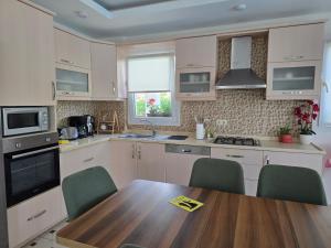 a kitchen with a wooden table and green chairs at Dalyan Villa Amazon in Dalyan