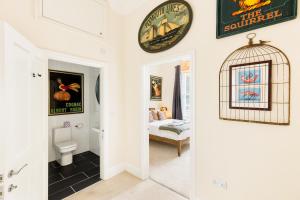 a bathroom with a toilet and a bird cage on the wall at Maitland House Boutique Apartment in Gloucestershire +18 photos