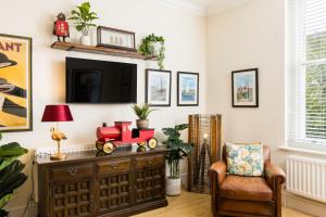 a living room with a wooden dresser with a toy train on it at Maitland House Boutique Apartment in Gloucestershire