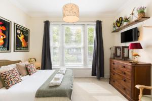 a bedroom with a bed and a window at Maitland House Boutique Apartment in Gloucestershire