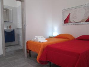 トッレ・ラピッロにあるAffittacamere Orienteのベッド2台とバスルームが備わるホテルルームです。