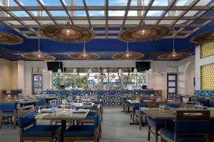 a dining room with tables and blue chairs at Hotel Eastport in The Villages