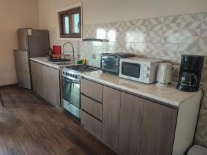 a kitchen with a stove and a microwave on a counter at Terraza Olmué Piscina y Tinaja Uso Exclusivo in Olmué