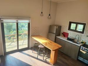 a kitchen with a wooden table and a refrigerator at Terraza Olmué Piscina y Tinaja Uso Exclusivo in Olmué