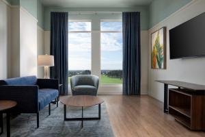 a living room with a couch and chairs and a large window at Hotel Eastport in The Villages
