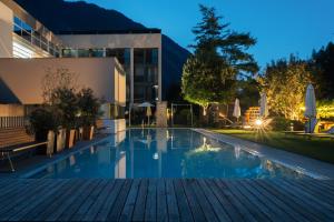 a swimming pool in front of a building at night at Valavier Aktivresort in Brand