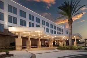 a hotel with a palm tree in front of a building at Hotel Eastport in The Villages