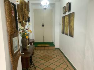 a hallway with a table and a vase of flowers at casa rural excentrico alcala in Vélez de Benaudalla