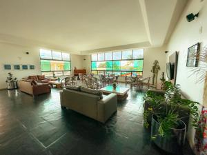 a large living room with couches and tables and windows at Xingó Parque Hotel in Canindé de São Francisco