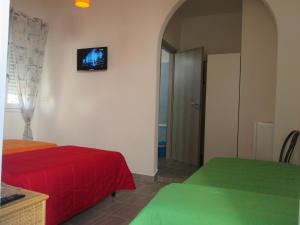 トッレ・ラピッロにあるAffittacamere Orienteのベッド2台、壁掛けテレビが備わる客室です。