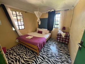 a bedroom with a bed with a zebra carpet at leyianmaasaisafaris in Narok