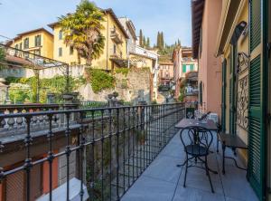 a balcony with a table and chairs on a building at Appartamento The Rich Man in Bellagio