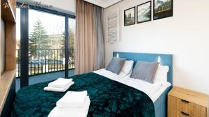 a bedroom with a large bed and a balcony at Wonder Home- Izeryn- centrum Świeradowa in Świeradów-Zdrój
