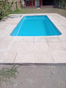 a blue swimming pool on a concrete floor at Casa con pileta Pedriel I in Ciudad Lujan de Cuyo
