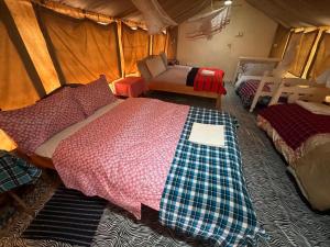 a bedroom with two beds in a tent at leyianmaasaisafaris in Narok