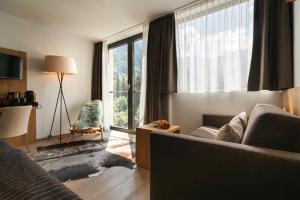 a living room with a couch and a large window at Valavier Aktivresort in Brand