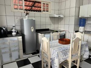 a kitchen with a table and two chairs and a refrigerator at Castelo Princesa Isabel in Ouro Preto