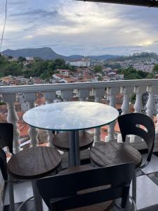 a table and chairs on a balcony with a view at Castelo Princesa Isabel in Ouro Preto