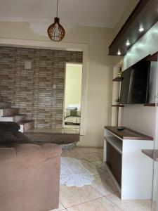 a living room with a couch and a television at Castelo Princesa Isabel in Ouro Preto