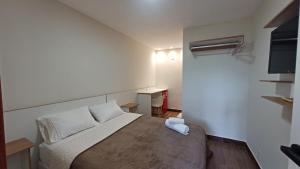 a small room with a bed and a television at Riviera Sanary 1206 - Nova Almeida in Serra