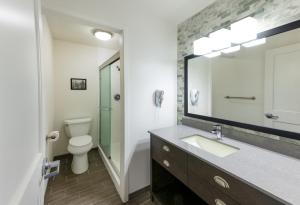 a bathroom with a sink and a toilet and a mirror at Lake Quinault Lodge in Quinault +54 photos