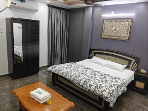 a bedroom with a bed and a mirror and a table at Khaleel Manzil Luxe Stays in Hyderabad