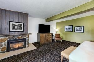 a hotel room with a fireplace and a television at Lake Quinault Lodge in Quinault