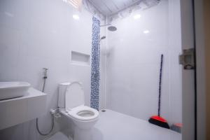 a white bathroom with a toilet and a sink at Azman in Fuvahmulah
