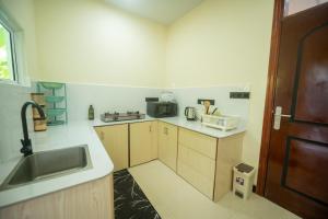 a small kitchen with a sink and a microwave at Azman in Fuvahmulah