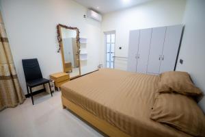 a bedroom with a bed and a chair and a mirror at Azman in Fuvahmulah +1 photo