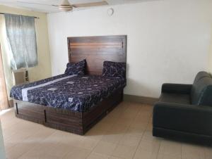 a bedroom with a large bed and a couch at Classic Hotel by TWM in Ibadan