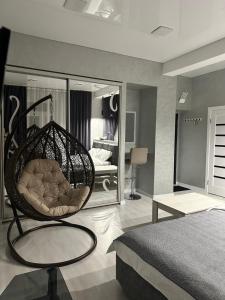 a room with a swing chair in a bedroom at Apartments Velora in Kryvyi Rih
