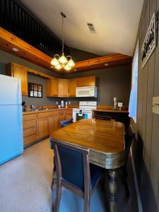 a kitchen with a wooden table and a refrigerator at Papa Chubbys RV Resort in Sunrise Beach